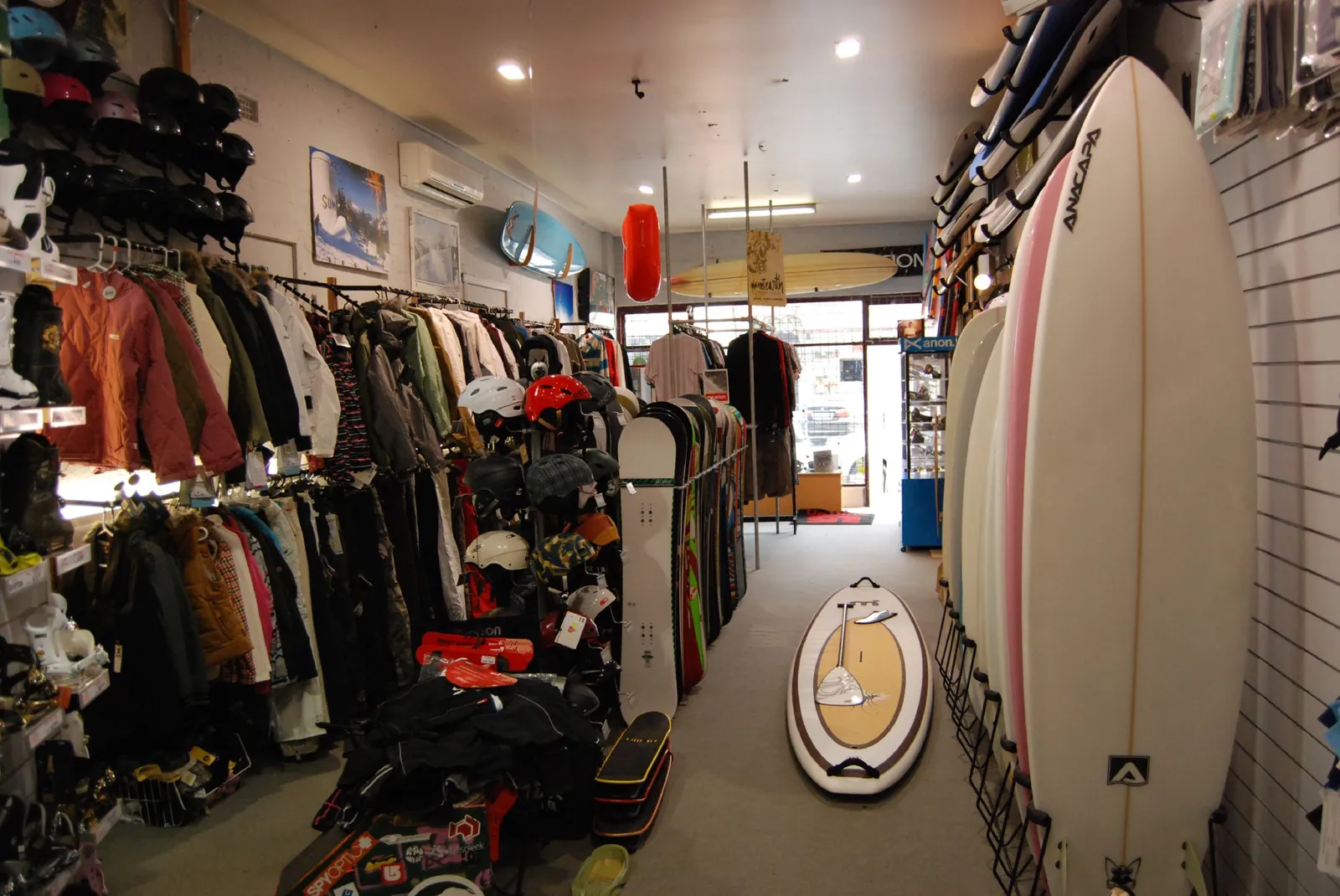 Intérieur d'un magasin de surf : planches, combinaisons et vêtements
